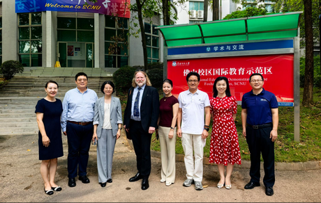 A group of eight staff from SCNU and Aberdeen stand in front of a building on SCNU's campus