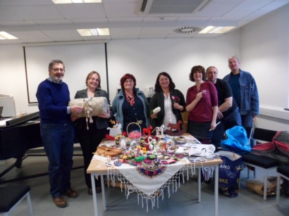 Group of people standing behind table covered in traditional Polish crafts