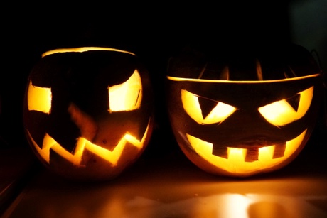 Two lit neep lanterns against a dark background