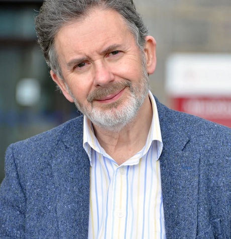 Photo of Ian Russell looking at the camera, standing in front of University building