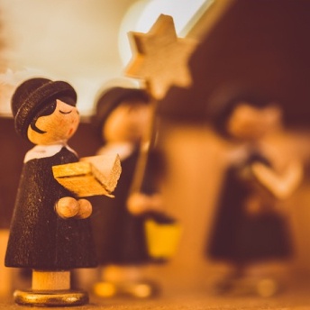 Little wooden figurines gathered together carolling.