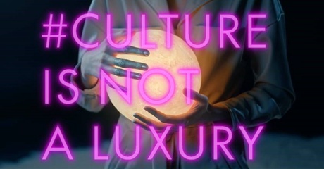 The words Culture is not a Luxury are lit up in pink