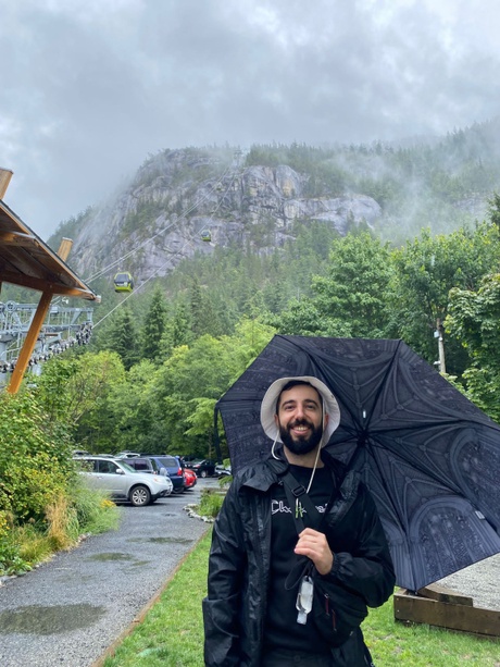 Picture of John standing in the rain with an umbrella