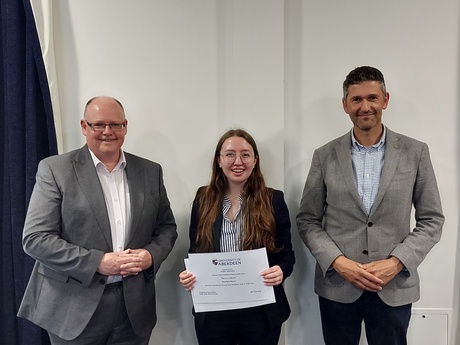 Photograph of Prize winner Karolena Brown, with their certificate, alongside Alisdair Sutherland and Head of Law School Prof Greg Gordon
