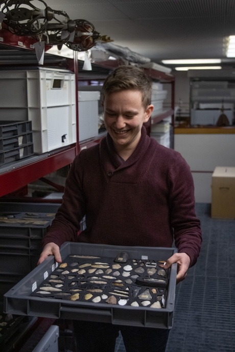 Curatorial Assistant Lise Bos holding a tray of museum objects