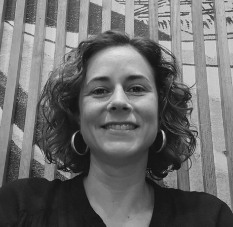 Greyscale profile of Dr Raquel Campos Valverde, in front of a decorated wooden wall.