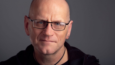 Dr Dave Camlin, in front of a grey background