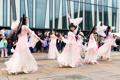 Women dancing outside Sir Duncan Rice Library