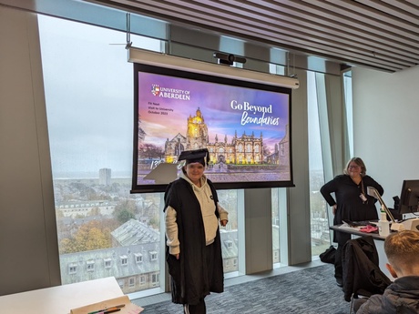 A young woman trying on a graduation cap and gown