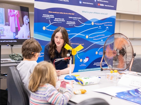 A female researcher engaging with a young boy and girl during a previous event