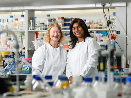 Professor Carol Munro and Dr Soumya Palliyil in white coats in a lab