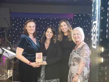 Nicola Pearce and Jade McGowan holding the award with the presenters