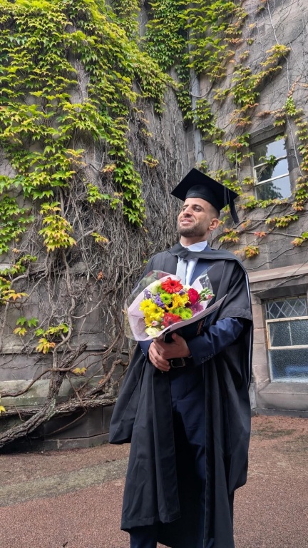 Eissa holding a bouquet of flowers outside New King's
