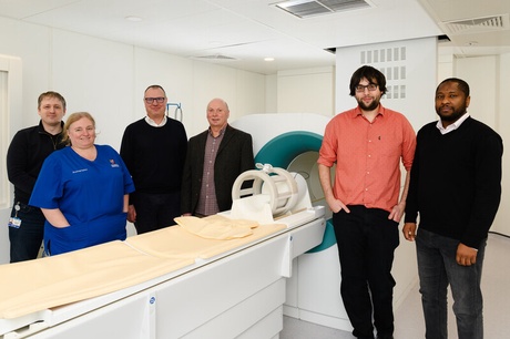 A group of people standing beside the new FCI scanner