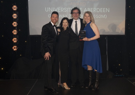 4 people holding an award