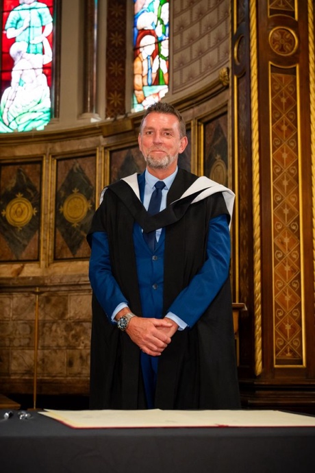 A person standing wearing academic robes