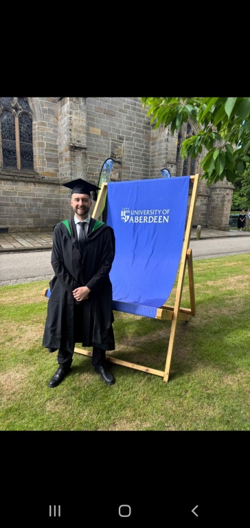 Matthew sitting on a deckchair after graduating