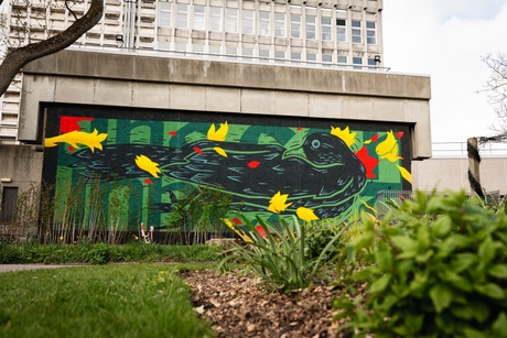 Nuart mural with the Zoology Building behind - a blackbird in KMG&rsquo;s trademark style with the words &ldquo;unheard, unseen&rdquo;
