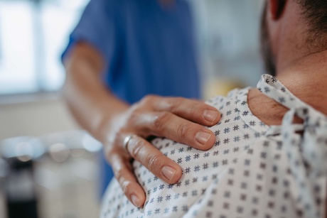 A doctor putting a hand on a patient's shoulder