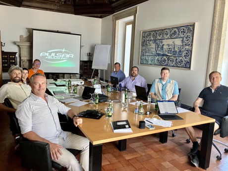 The pulsar team sitting around a table at a meeting