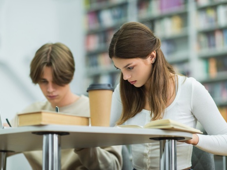A male and female school pupils sitting at a desk