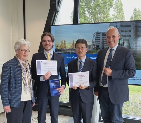 Four people standing with awards