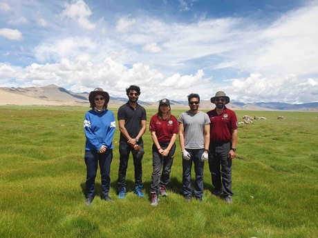 Five people standing in front of a mountain range in India