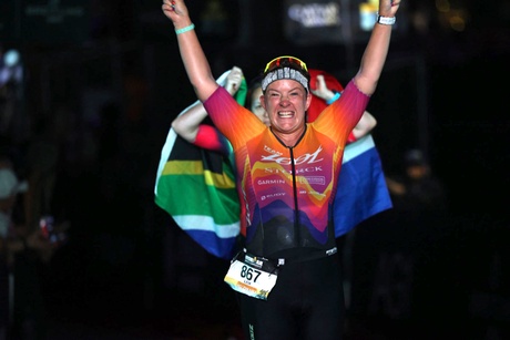 A person crossing a finishing line with arms raised