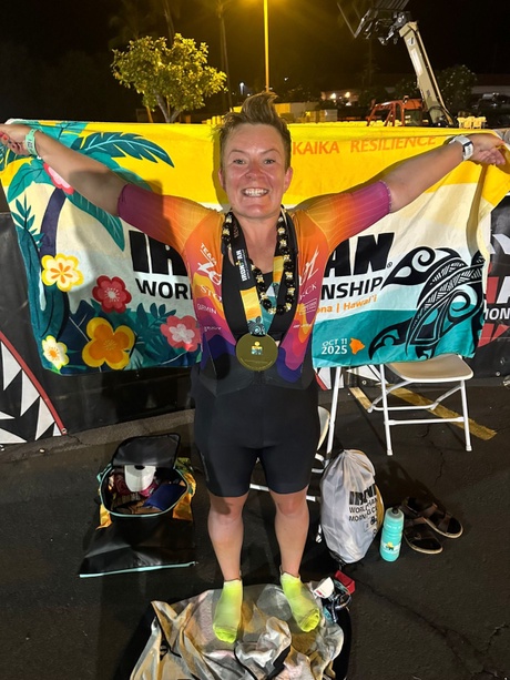 A person with arms outstretched holding a flag