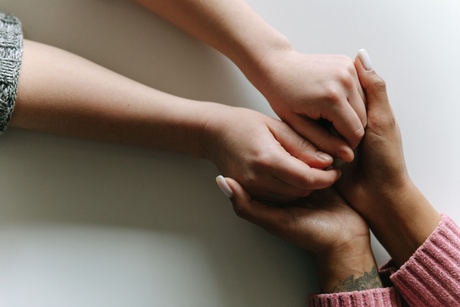 Two people holding hands across a table