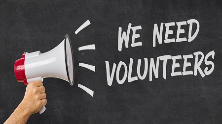 blackboard and loud speaker with the words we need volunteers