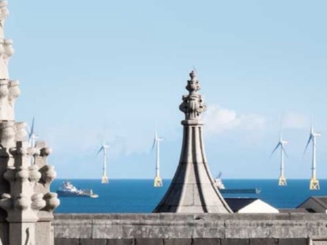 An offshore windfarm viewed from between the rooftop turrets of Aberdeen city centre buildings