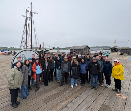 Lauren and others who attended the NoWPaS workshop stood on a pier in front of a boat