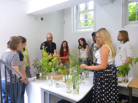 A group of people stood around a table with flowers on it