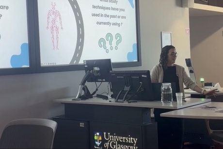 A woman sat at a desk giving a presentation