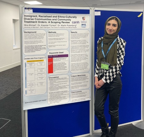 Hira stood beside her research poster titled &lsquo;Immigrant, Racialised and Ethno-Culturally Diverse Communities and Community Treatment Orders: A Scoping Review'