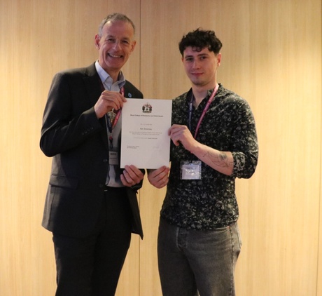 Two people stood holding a certificate