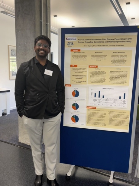 Student Prem stood next to his project poster