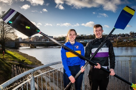 A photograph of Kirstin McCallum (UoA) and Michael Troy (RGU) smiling and holding oars with the River Dee in the background