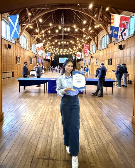 Giang holding her certificate in Elphinstone Hall