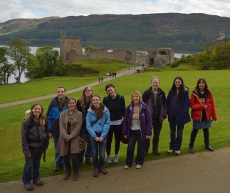 Students and staff standing in front of Urquhart Castle