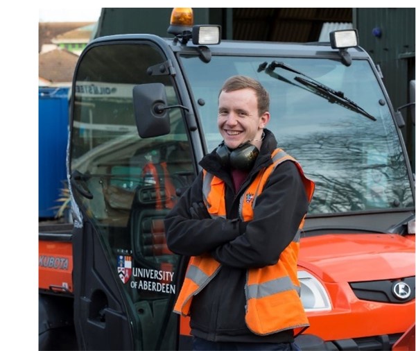 Owen Griffin smiling while leaning on a University of Aberdeen grounds maintenance vehicle