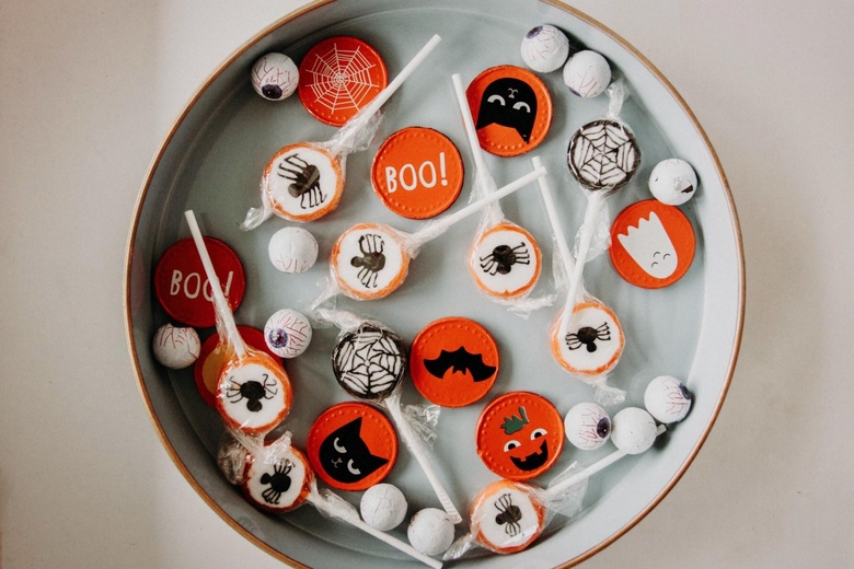 A plate with different lollies and sweets decorated in halloween colours and designs
