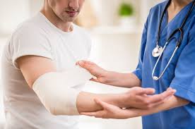 Image of a nurse putting a bandage on a mans elbow