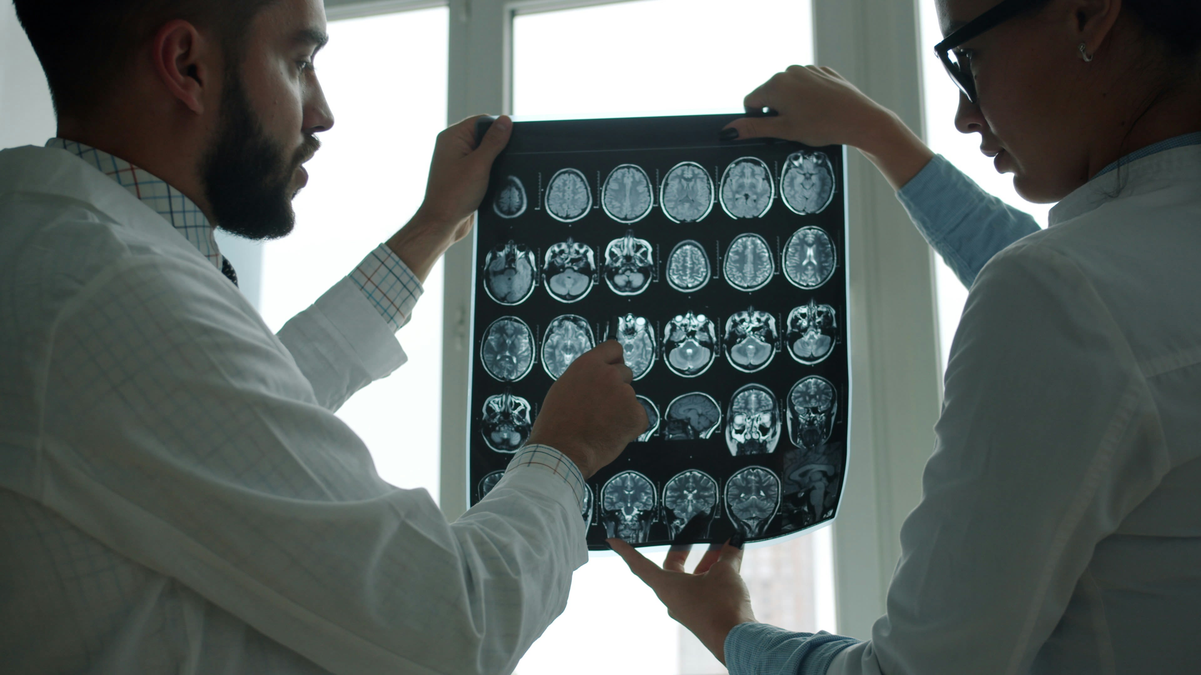 Two doctors examining a brain mri scan together.