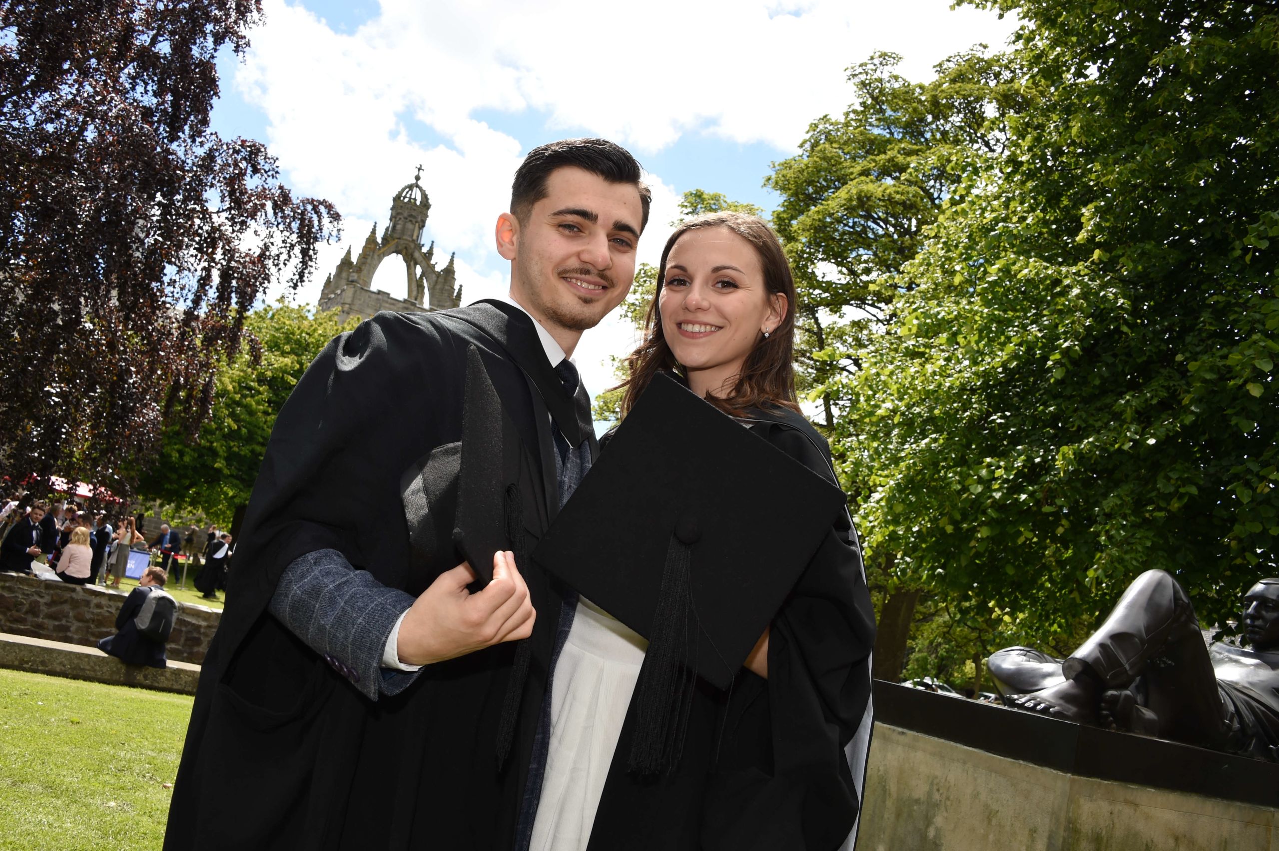 Agathe Dugleux and Cosmin Mogosanu in their graduate gowns smiling at the camera.