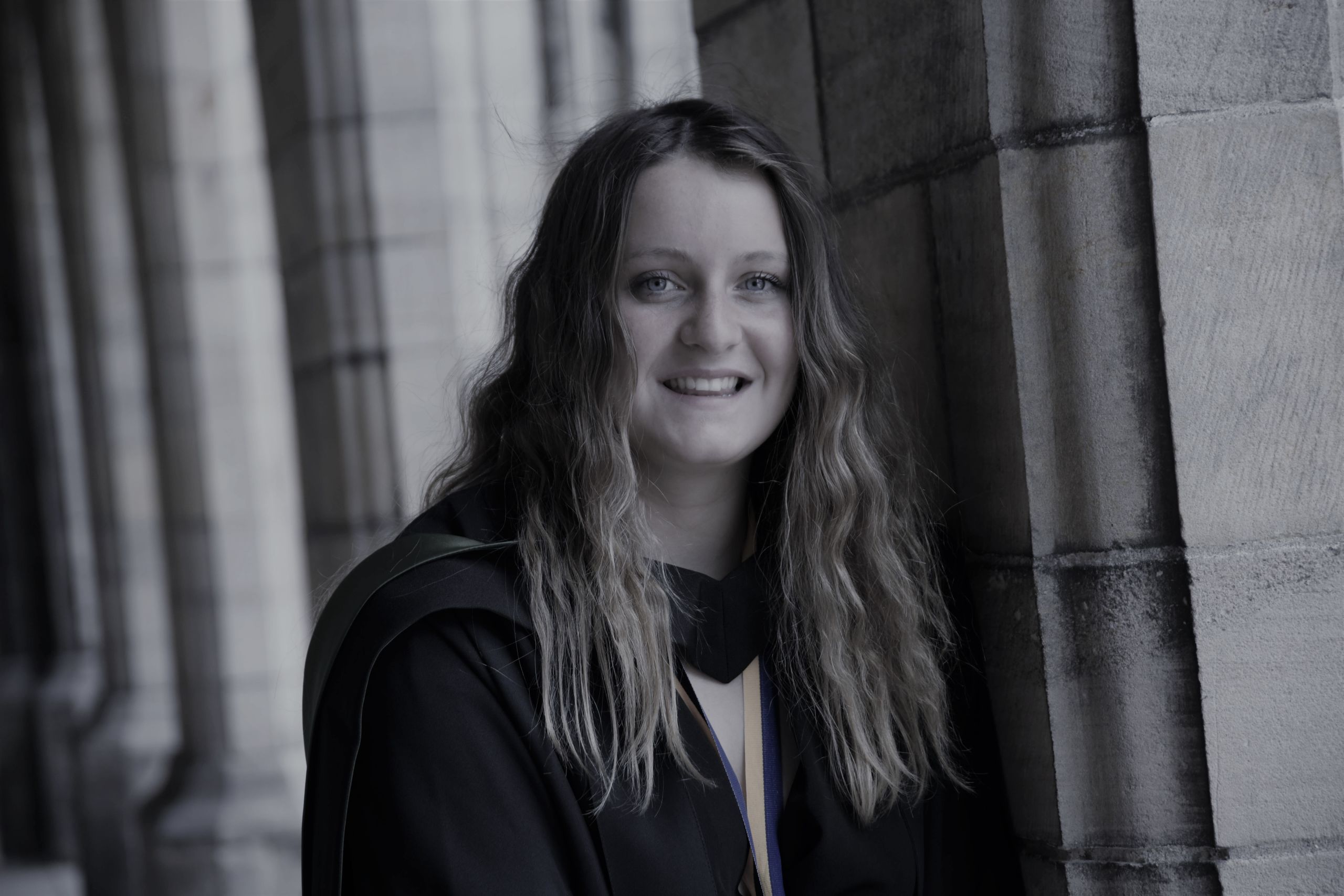 Megan Mackay smiling and standing under the arches of the Elphinstone Hall.