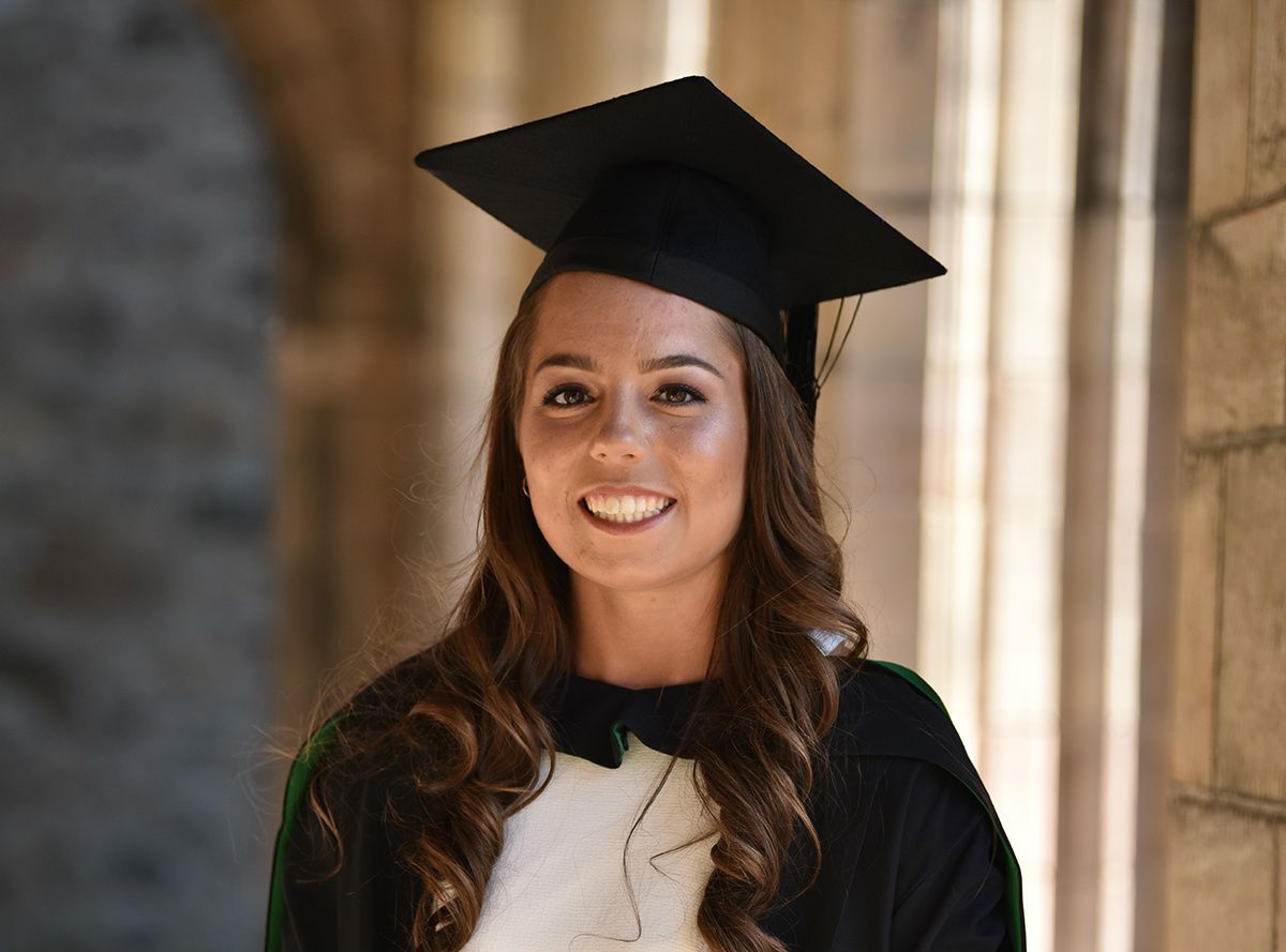 Kelsey Stewart smiling with her graduate cap on.