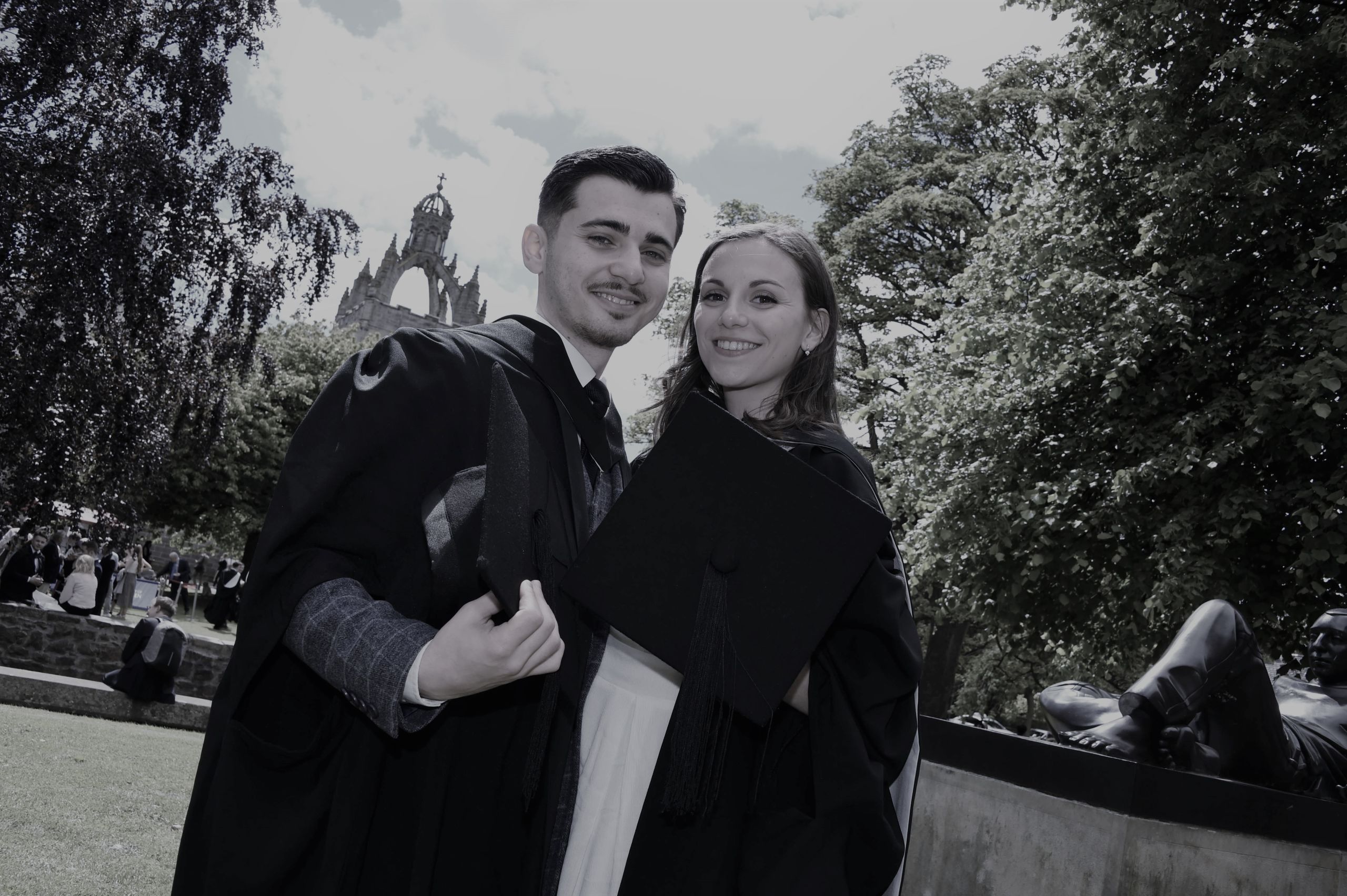 Agathe Dugleux and Cosmin Mogosanu in their graduate gowns smiling at the camera.