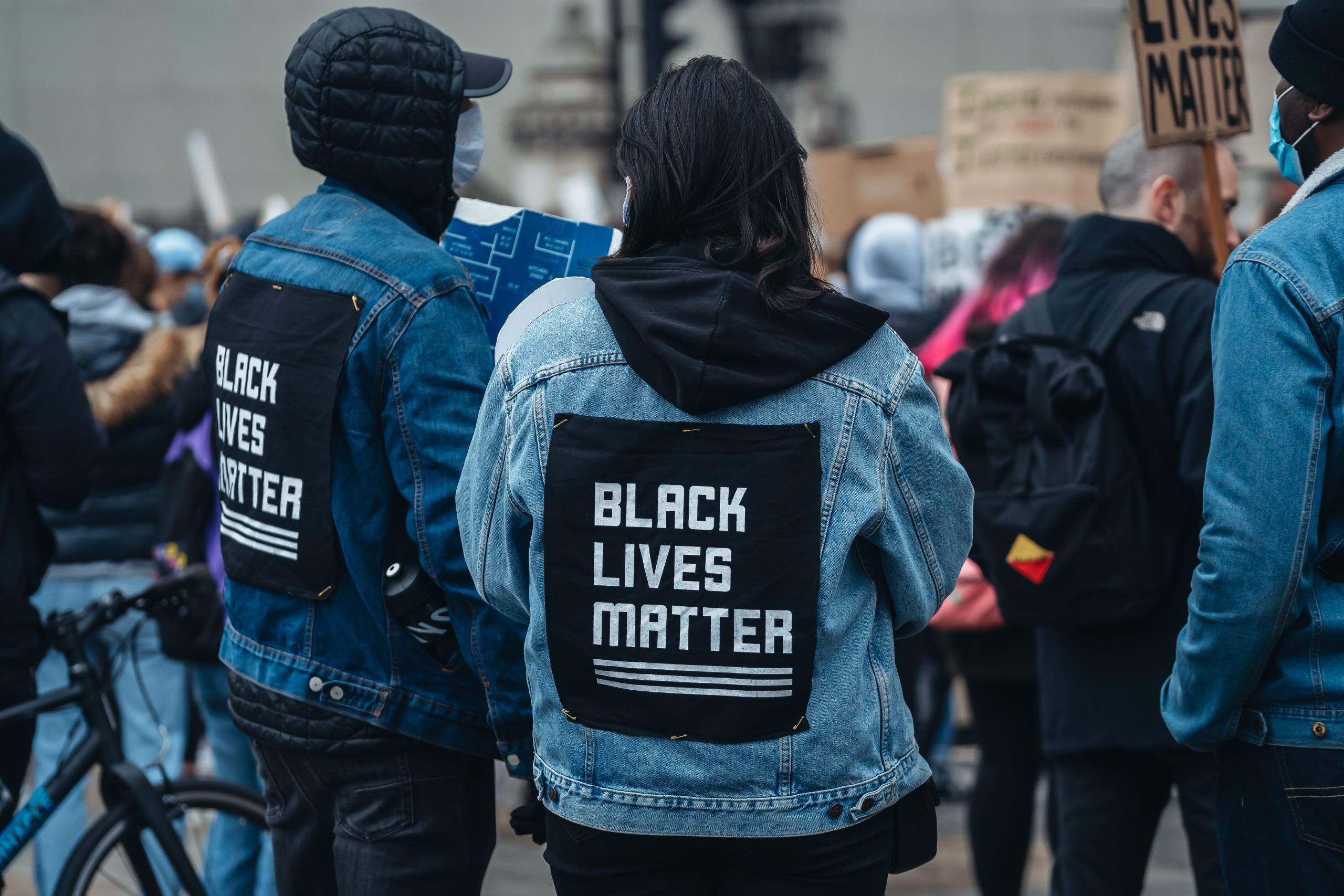 Protesters wearing denim jackets with "Black lives matter" writing on them